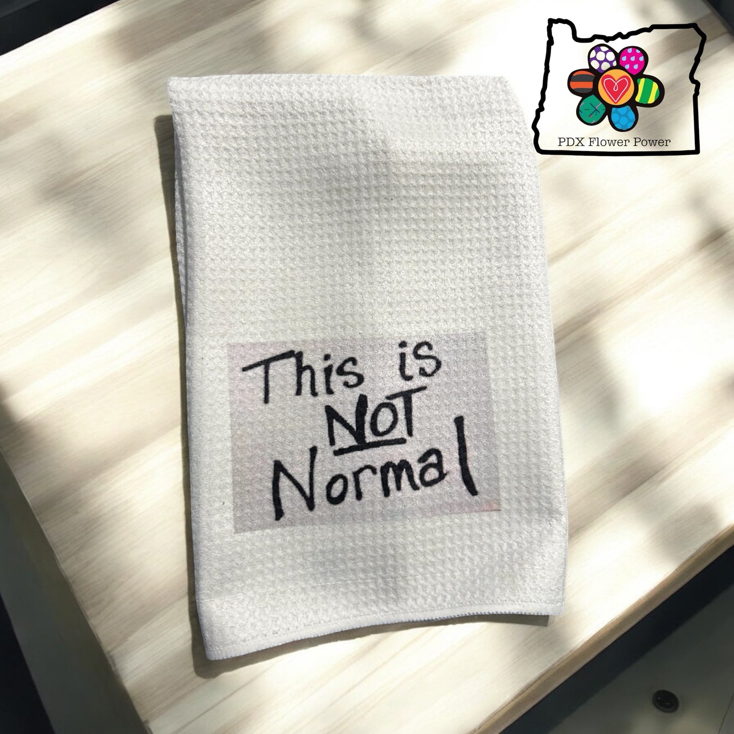 "This is Not Normal" dish towel featuring NM Representative Melanie Stansberry's sign & a Jack Ohman tote